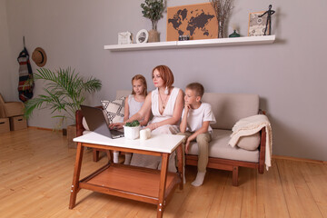 Fototapeta premium mother teaches children at home. homeschooling. the teacher is engaged with schoolchildren at home. mom shows children a task in a computer