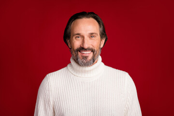 Obraz premium Portrait of mature handsome good looking happy positive smiling man in turtleneck isolated on red color background