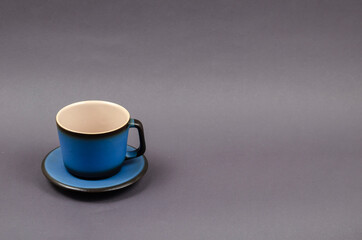Blue cup and saucer on a gray background.