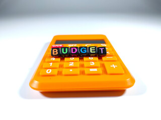 Selective focus.Word BUDGET from a black dice with calculator on white background.Shot were noise...