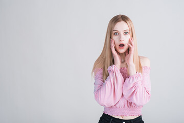 Portrait of shocked young blonde in studio against white background with copyspace