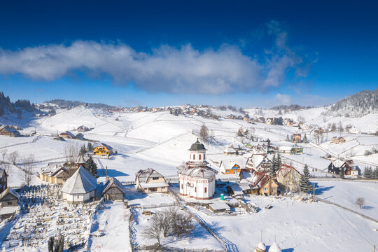 Aerial scenic rural view of the winter landscape from Fundata village in Romania at the bottom of Bucegi Mountains 