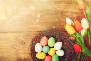 Easter decorations with tulip flower and eggs over a wood table