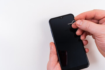 men's hands insert a SIM card into a smartphone using a clip key. subscriber's electronic module used in mobile communications. 4G Internet