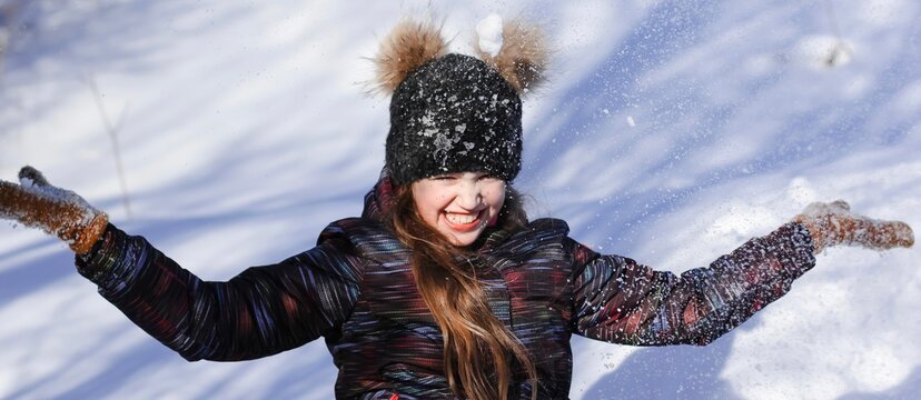 A cute ten years old girl having fun on a winter day outdoors. Wintertime, entertainment, activity, childhood, holidays, christmas concept. Banner. © Татьяна