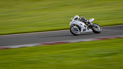 Fototapeta premium A panning shot of a racing motorbike as it circuits a track.