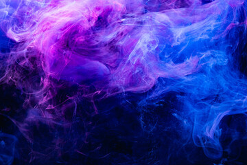 Paint in water. Colorful art background. Fluorescent smoke texture. Universe energy. Glowing bright...