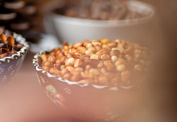 Brown ceramic bowl with peeled Siberian pine nuts. 