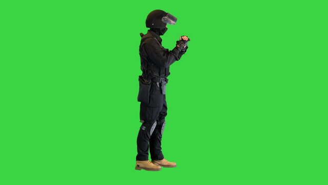 Police tactical officer checking his hand gun and folding hands on a Green Screen, Chroma Key.