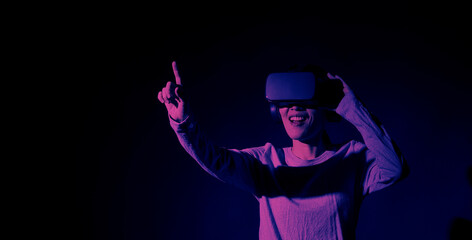 Girl with hands up wearing the VR headset goggles. Asian woman in glasses of virtual reality. The concept of futuristic. Digital VR glasses. Woman getting cyber experience using modern black color VR.