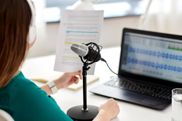 technology, mass media and people concept - close up of woman with microphone and laptop computer...