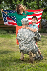 Happy reunion of soldier with family outdoors	