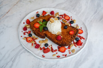 Crispy French toast with berry. A toast baking with butter and crumble topped with vanilla ice cream, served with berry fruits ; strawberry and blueberry.