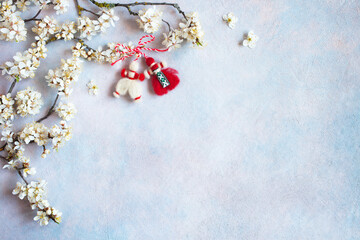 Blooming branches of cherry plums and decor red and white symbol of the holiday of spring March 1 on a decorative background for text, congratulations