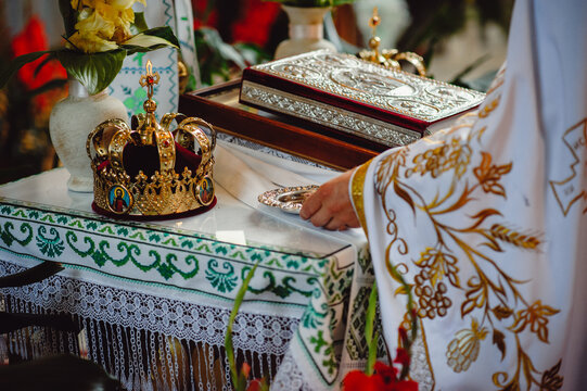 The priest prepares for the wedding ceremony. golden crowns and bible and wedding ring on altar in church at wedding matrimony. traditional religious wedding ceremony