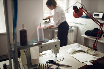 young girl seamstress while working on tailoring in her workshop