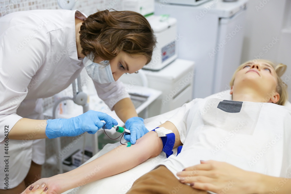 Wall mural taking blood from a vein close-up. blood test in the hospital. the doctor's hands draw blood from a 