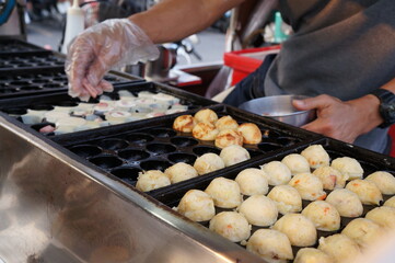 Employees are making Japanese food takoyaki. 