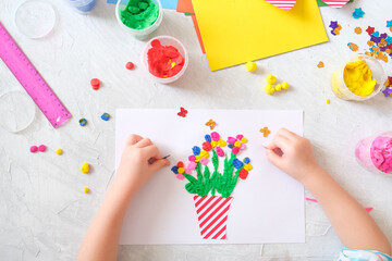 Child making homemade greeting card. little girl making vase with flowers from paper and clay, plasticine as gift for Mothers day, Birthday or Valentines day . Arts  crafts concept.