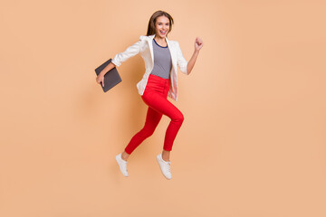 Fototapeta na wymiar Full length photo of lady jump run step hold laptop wear white blazer isolated pastel beige color background