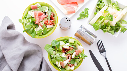 Summer mediterranean salad with ham and melon on white table top