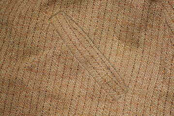 brown texture from a piece of woolen cloth with a stripe and pocket