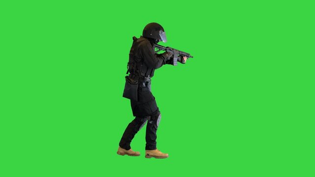 Police anti terrorism squad fighter shooting from rifle on a Green Screen, Chroma Key.