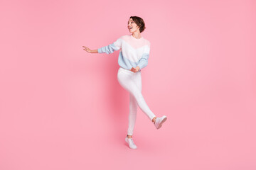 Photo portrait full body view of cute dancng girl kicking looking at blank space isolated on pastel pink colored background