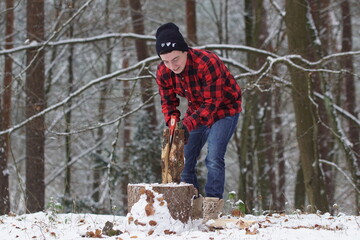 Holz hacken - Mann hackt Holz im Winter im Wald