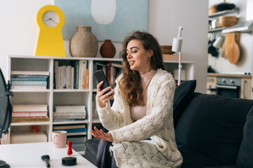 woman drinking morning coffee and using smartphone at her home