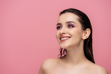 happy young woman with makeup smiling isolated on pink