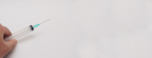 Man holds empty disposable syringe on white background.