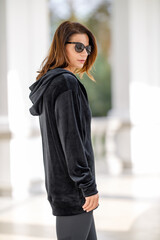 Fototapeta premium Young woman dressed in fashion hoodie posing outdoor