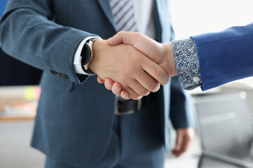 Two businessmen are shaking hands friendly closeup