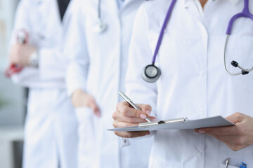 Doctors in white medical coats stand together