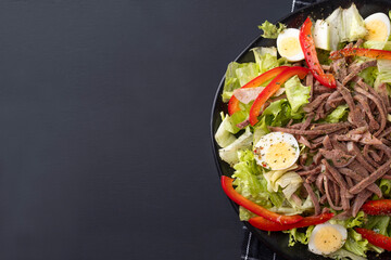 Beef tongue salad on dark background. Top view, text space