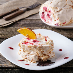 Merengue roll with raspberry on a plate
