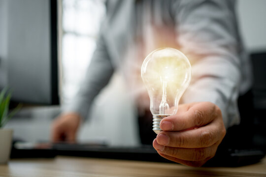 Businessman holding lightbulb and feeling happy by new innovation and ideas for success business panels. Concept of innovation creative technology ideas for Business solution