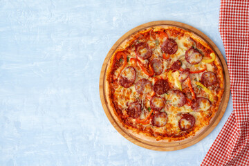 Delicious pizza with sausages on gray background