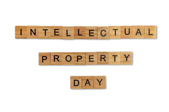 Top view of the word intellectual property day laid out from square wooden tiles isolated on white background. World and international day.
