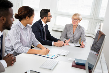Mature businesswoman explains to colleague a new project