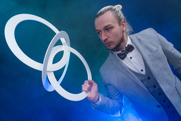 Man wearing formal suit juggling with white rings. Management, control and success