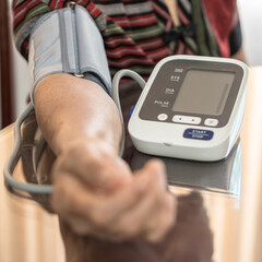High blood pressure, hypertension and cardiovascular disease in aged senior older elderly woman with bp, heart rate, digital pulse check equipment for medical geriatric awareness in heart stroke