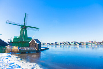Vintage beautiful Dutch houses, old windmills, frozen water in canals and rivers.