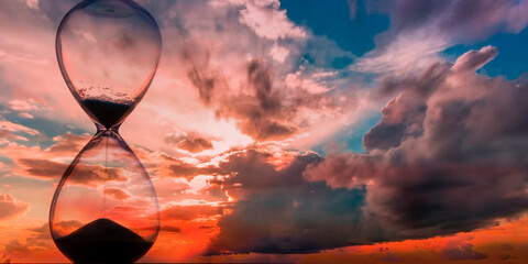 Time passing at sunset with hourglass

