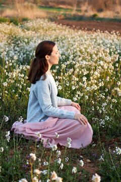 woman meditating among flowers mindfulness concept