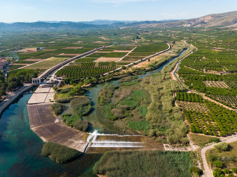 Antella weir in Jucar river (Azud de Antella) surrounded by orange-tree fields in the province of Valencia, Spain