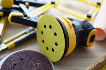Yellow disc sander is on table. Tool for processing wood and other coatings concept