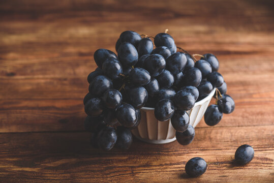 Vintage Bowl of Dark Blue Grapes on Wooden Table