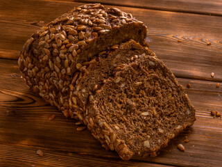Loaf of whole grain bread on wooden background